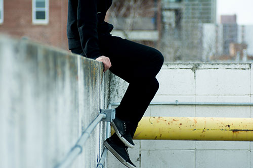 Teenager sitting on a ledge